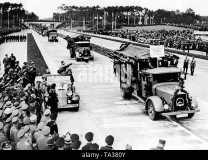 Adolf Hitler im Auto an der Parade der Bauarbeiter in Mercedes-Benz Lo 2000 Lkw anlässlich der Eröffnung der Reichsautobahn route Frankfurt/Main - Darmstadt (heute A5) auf dem Messegelände in Darmstadt. Stockfoto