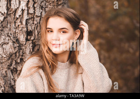 Schöne lächelnde blonde Mädchen 16-18 Jahre alten posiert im Freien. Mit Blick auf die Kamera. Teenagerhood. Stockfoto