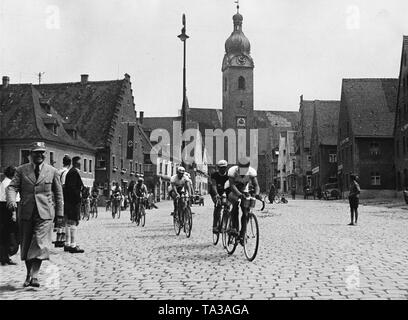 Das Peloton der Straße Meisterschaften Juli 22, 1934 durch einen Platz in einem bayerischen Dorf. Stockfoto