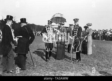 Kronprinz Wilhelm (3. von links) in der Uniform der Totenkopfhusaren ((1. Leib-Husaren-Regiment Nr. 1 Danzig) zusammen mit seiner Frau Kronprinzessin Cecilie (4. von links) mit Schirm und Prinz Friedrich Karl von Preußen (5. von links) am Ostern Rennen in Karlshorst. Stockfoto