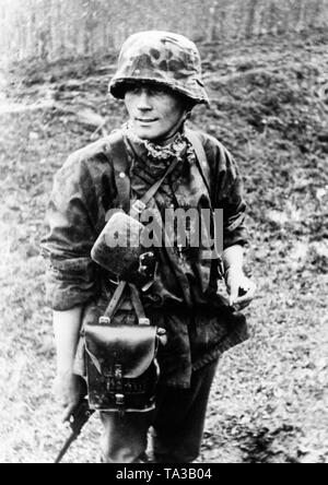 Ein Offizier der Waffen-SS mit einer Zigarette vor dem nächsten Angriff. Er hält einen Luger 08 Pistole. Stockfoto