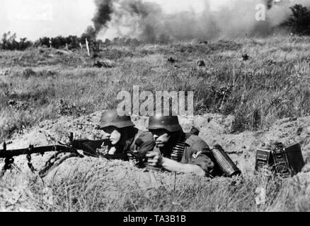 Deutsche Infanteristen mit einem Mg-34 in Position in einer Shell Krater. Stockfoto