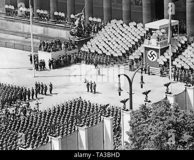 Farbe Einheit der Legion Condor (mit den Farben, den Spanischen bandera) vor dem Rednerpult im Lustgarten, Berlin. Auf der linken Seite, Adolf Hitler und Feldmarschall Allgemeine Hermann Goering sind durch eine Spalte der Legionäre. Im Hintergrund, Soldaten der Garde Regiment. Mitglieder der Hitlerjugend halten, die Namensschilder der, als auch die Fassade des alten Museums gefallen. Auf der linken Seite am Rücken, ein Sockel für Film Kameras gebaut für die "Wochenschau" (Wochenschau Serie). Stockfoto