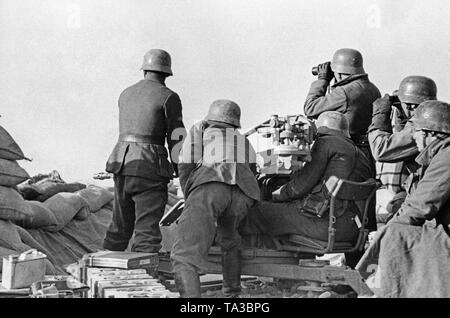 Undatiertes Foto von einer anti-Flugzeuge der Legion Condor während einer Bereitstellung im Spanischen Bürgerkrieg. Zwei Männer sind, die auf dem Boden mit einer 2-cm-FLAK 39 Ziel in einem sandsack Stellung. Ein Offizier (links) nimmt die Ziele. Links in der Front gibt es Kisten Munition. Die Soldaten tragen M 35 Stahlhelme. Stockfoto