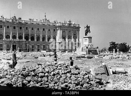 Foto der Plaza del Oriente in Madrid nach der Invasion der Spanischen Truppen unter General Francisco Franco im Frühjahr 1939. Im Hintergrund, die Spanischen Königspalast (Palacio Real). Vor ihr, das Reiterstandbild von König Philip IV (Felipe IV, 1605-1665). Das Pflaster des Platzes ist für barricade Bau aufgerissen. Kinder spielen. Stockfoto