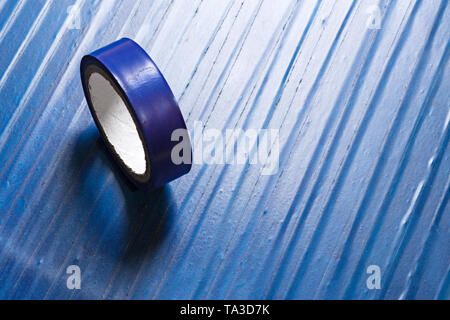 Eine Rolle der alten blauen PVC-Klebeband auf der Oberfläche durch gleiche Klebeband bedeckt Stockfoto