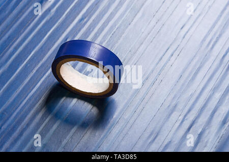 Eine Rolle der alten blauen PVC-Klebeband auf der Oberfläche durch gleiche Klebeband bedeckt Stockfoto