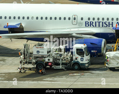 Der Flughafen London Gatwick, ENGLAND - April 2019: Menzies Aviation Fuel Truck neben einem British Airways Jet am Flughafen Gatwick Stockfoto