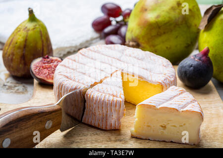 Rundes Stück französischer Käse Fleur Rouge aus Kuhmilch hergestellt als Dessert serviert mit frischen Feigen und Birnen Nahaufnahme Stockfoto