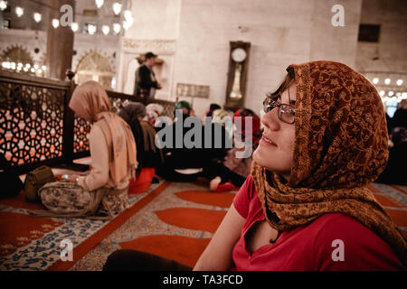 Istanbul, Türkei - 8 April, 2012: muslimische Frau mit Schleier innerhalb einer Moschee, von Männern durch einen Zaun getrennt. Stockfoto