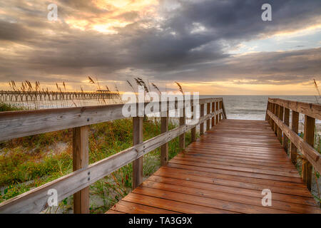 Sunrise entlang der Promenade über eine Sanddüne in Myrtle Beach, South Carolina Stockfoto
