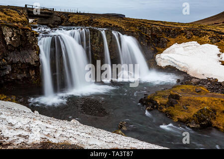 Kirkjufellsfoss Wasserfällen durch schmelzenden Schnee im Februar umgeben Stockfoto