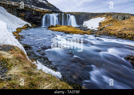 Kirkjufellsfoss, Wasserfälle bei Kirkjufell, durch die Schneeschmelze im Frühjahr umgeben Stockfoto