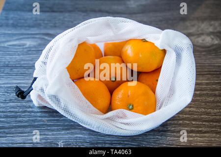 Mandarinen aus dem Supermarkt gekauft in einer wiederverwendbaren produzieren Beutel upcycled aus einem weichen Kunststoff Taschen. Umweltfreundliche Wahl. Stockfoto