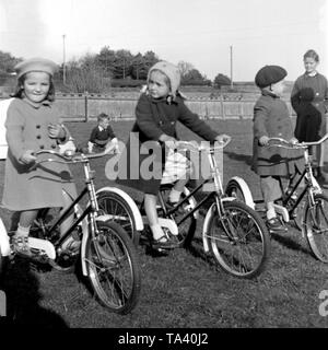 Junge Kinder, die drei tricylces Bei Gracie Fields Waisenhaus in der Nähe von Peacehaven vermutlich in den frühen 1960er Jahren. Stockfoto