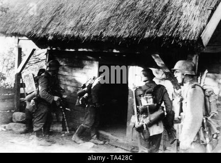 Ein Angriff der Wehrmacht sucht ein Haus in der Ortschaft Lazdijai an der Grenze zwischen Polen und Litauen. Bereich Army Group North während der ersten Tage der Östlichen Kampagne. Links im Bild, ein Soldat mit Radio. Stockfoto