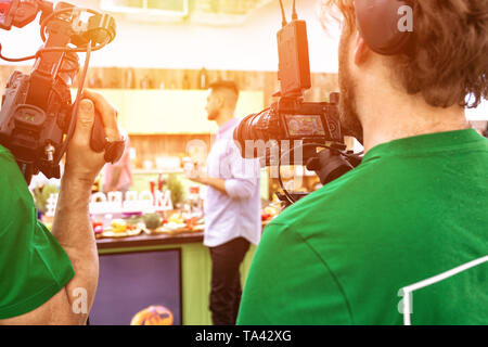 Videographer schießen ein Film oder ein Fernsehprogramm in einem Studio mit einer professionellen Kamera, Backstage Stockfoto