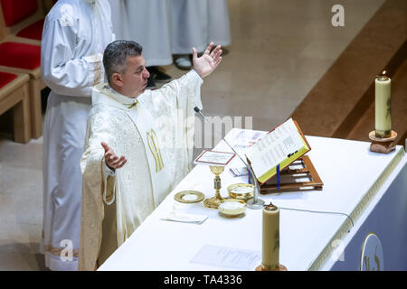 Zagreb, Kroatien - 5. Mai 2019: Der Priester auf dem Altar hält das Gebet während der Kommunion in der Kirche von Allerheiligen in Zagreb, Kroatien. Stockfoto