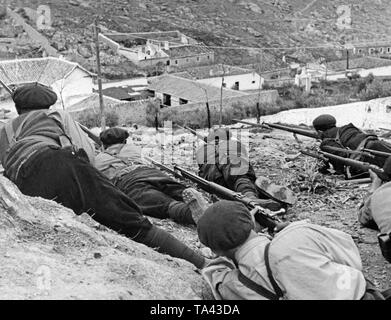 Nicht-regulären Spanischen Soldaten lauern mit Karabiner und Bajonette in der Lage, auf einem Hügel über einem Dorf in der Nähe von Madrid während der Schlacht von Madrid, 1937. Die Soldaten tragen Zivilkleidung: Hosen, puttees, einfache genagelt Stiefel, Pullover und baskenmützen. Stockfoto