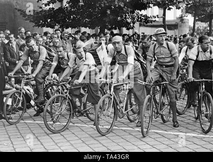 Die Teilnehmer der Meisterschaft von paperboys der Scherl sind bereit, das Rennen in der Siemensstraße in Berlin-Moabit zu starten. Sie tragen Rucksäcke. Stockfoto