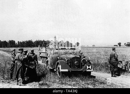 General Heinz Guderian (3. von links, vorne), Kommandant der 2. Panzer Gruppe von Army Group Center am Tag des Angriffs im Bug. Im Hintergrund, eine sowjetische Aussichtsturm. Das Fahrzeug auf der linken Seite ist ein schützenpanzer des Typs Sd.Kfz. 250 mit Funkgeräten. Stockfoto