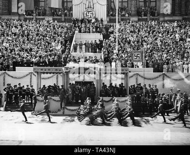 Hitler erhält den Bericht von General der Flieger Hugo Sperrle während des pastmarch einer Band der Legion Condor. Hermann Goering, Erich Raeder, Walther von Brauchitsch, Wolfram von Richthofen und Wilhelm Keitel, stand in der Mitte der Haupttribüne (von links). Auf der rechten Seite der Haupttribüne, Erhard Milch und anderen Soldaten der Wehrmacht und der Spanischen Nationalen Armee. Der linke Flügel der Tribüne ist von spanischen Offizieren besetzt. Auf den Seiten der Tribüne ist eine Delegation der SS. Die Hakenkreuzfahne ist die persönliche Standard von Adolf Hitler. Stockfoto