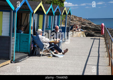 Touristen, Nachmittagstee und Snacks außerhalb einer Strandhütte im Swanpool, in der Nähe von Falmouth, Cornwall, Großbritannien Stockfoto