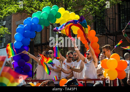 NEW YORK CITY - 25 Juni, 2017: Teilnehmer wave Regenbogenfahnen auf einem Schwimmer, der mit einem Ballon arch in der jährlichen CSD-Parade in Greenwich Village. Stockfoto
