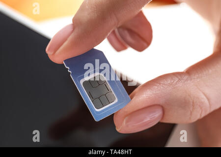 Frau mit SIM-Karte und Handy, Nahaufnahme Stockfoto