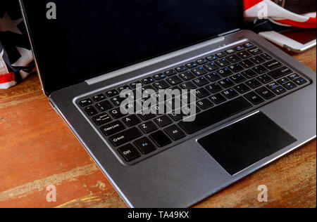 Laptop von Büromaterial und Gadgets auf alten hölzernen Schreibtisch öffnen Stockfoto