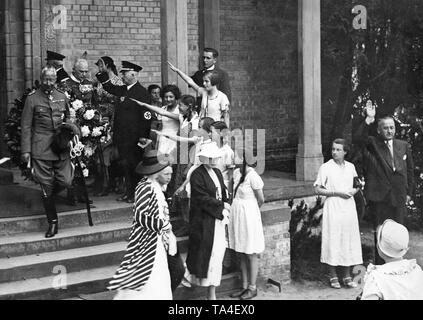 Kronprinz Wilhelm (links) in der husar Uniform, Verlassen der Waldkirche in Nikolskoe (heute ein Stadtteil von Berlin) nach einer Trauerfeier. Er ist mit dem Hitlergruß von einigen Kindern begrüßt. Der Service war durch eine Kranzniederlegung am Grab des Kronprinzen Friedrich Karl gefolgt. Stockfoto