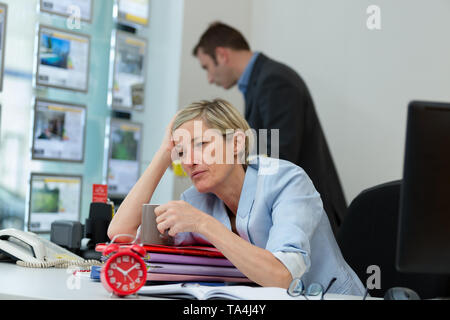Müde Geschäftsfrau arbeitet in einem Büro Stockfoto