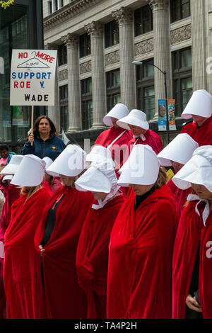 Frauen Rallye in Chicago Federal Plaza die reproduktive Freiheit angesichts der vielen Staaten, strenge Abtreibung verbietet zu schützen. Die Demonstranten auf der Plaza um 5 Uhr zu reden hörte und dann marschierte durch die Schlaufe geführt durch Dutzende von Frauen gekleidet als Mägde von dystopischen Roman Margaret Atwood's, die Geschichte der Dienerin. Stockfoto