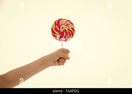 Verständnis Rolle Zucker junge Diäten. Hand von Kid Kind hält bunte Lollipop isoliert weißer Hintergrund. Kinder haben angeborene Fähigkeit Diät Energie Aufnahme einstellen. Süße Leckereien in Diät haben können. Stockfoto