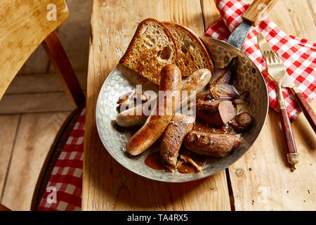 Mit der sortierten Wild Wild Fleisch mit saftigen Wildschwein und Reh Filets und würzigen Würstchen in einer Schüssel mit Soße und geröstetem Roggen Brot Stockfoto