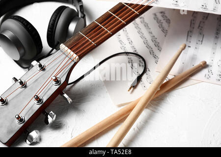 Zusammensetzung mit Gitarre, Kopfhörer und Noten auf weißem Hintergrund Stockfoto