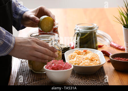 Frau mit leckeren fermentiertes Gemüse in der Küche Stockfoto