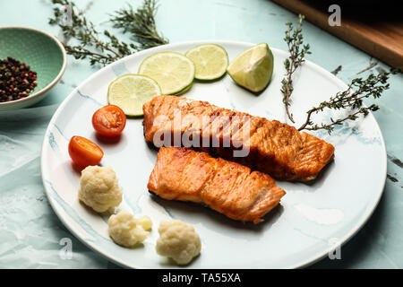 Stücke von lecker gegrillter Lachs mit Gemüse auf dem Teller Stockfoto