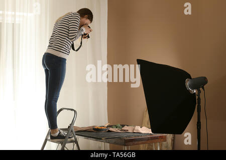 Junge Frau der Aufnahme von Nahrungsmitteln im professionellen Studio Stockfoto