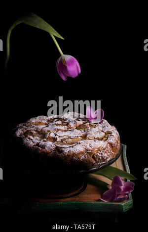 Apple und Berry Kuchen mit Blumenschmuck auf Mittelstücke, düstere Stimmung Stockfoto