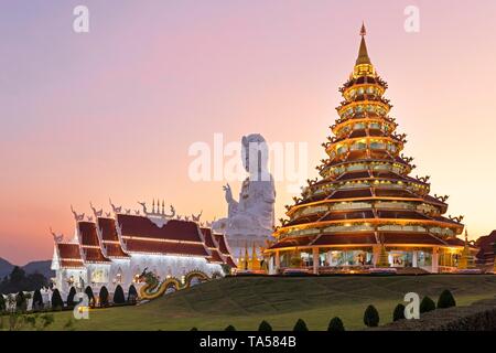 9-stöckiges chinesische Pagode und Kapelle die vor riesigen Guan Yin Statue bei Sonnenuntergang, Wat Huay Pla Kang Tempel, Kuan Yin, Chiang Rai, Nordthailand Stockfoto