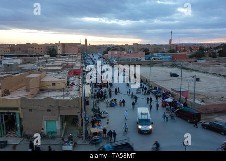 Rissani, Marokko - März 21., 2019: Ein Blick auf die Main Street mit beschäftigten einheimischen während des Sonnenuntergangs. Stockfoto