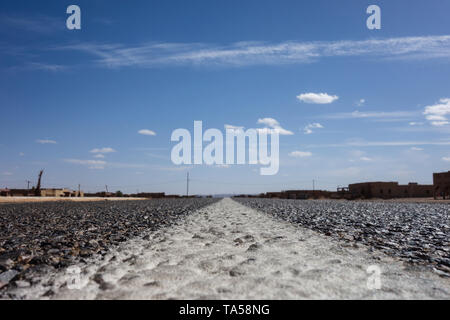 Nahaufnahme eines marokkanischen Autobahn mit einer Wüstenlandschaft mit Sanddünen von Merzouga, Marokko Stockfoto