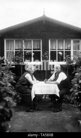Paare, ältere Paare in den Schrebergarten sitzen am Tisch vor der Laube, um 1920, Deutschland Stockfoto