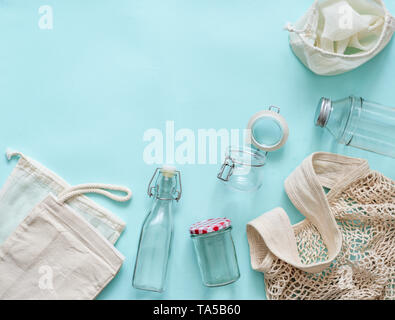 Null Abfall Konzept. Textile eco Beutel, Gläser und Glasflaschen auf blauem Hintergrund mit Kopie Platz für Text oder Design. Umweltfreundlich und Wiederverwendung conce Stockfoto