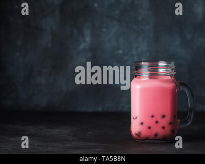 Hausgemachte Milch Bubble Tea mit Tapioka Perlen Kugeln. Beliebte Taiwan Bubble Tea in Glas Marmeladenglas mit Kopie Platz für Text. Bubble Tea auf dunklen backgrou Stockfoto