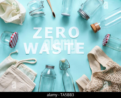 Null Abfall Konzept. Textile eco Beutel, Gläser und Bambus Zahnbürste auf blauem Hintergrund mit Null Abfall Weißbuch Text in der Mitte. Umweltfreundlich und Stockfoto