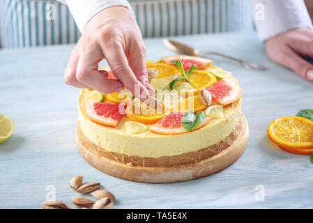 Rohe Zitrusfrüchte Kuchen mit Grapefruit, Orange, Limette und Zitrone mit Muttern und Minze. Kochen zu Hause gesund Sommer vegane Dessert Stockfoto