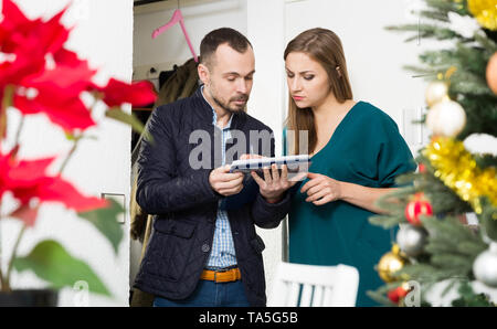 Junge Frau in Umfrage durch männliche Sozialarbeiter zu Hause vor dem Neuen Jahr teilnehmenden Stockfoto