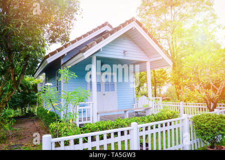 Kleines Haus Garten/Blue House Cottage garten sommer in grüne Pflanze und Baum Hintergrund Stockfoto